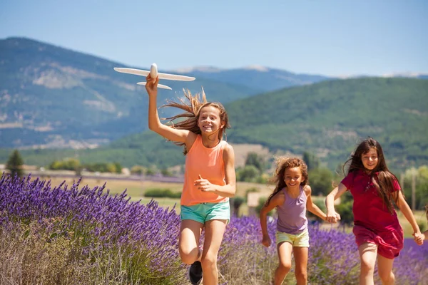 Chica Feliz Corriendo Con Sus Amigos Sosteniendo Avión Juguete Prado — Foto de Stock