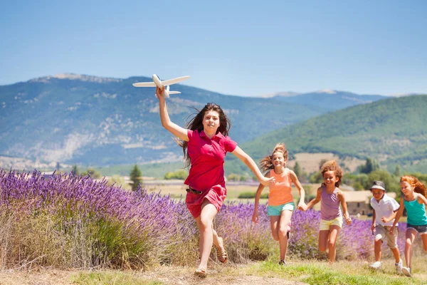 Laufende Kinder Jagen Mädchen Mit Spielzeugflugzeug Lavendelwiese — Stockfoto