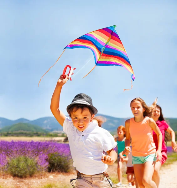 Close Portrait Happy Boy Flying Rainbow Kite While His Friends — Stock Photo, Image