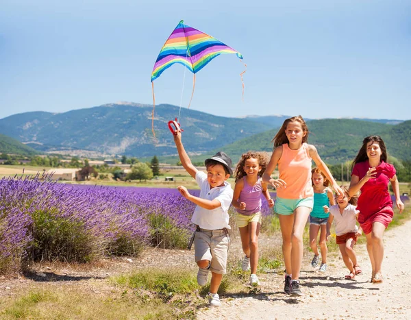 Opgewonden Jongen Vliegen Rainbow Kite Terwijl Zijn Vrienden Loopt Naar — Stockfoto