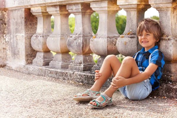 Portrét Šťastný Chlapec Sedí Podlaze Blízkosti Kamenné Zábradlí Venku Létě — Stock fotografie