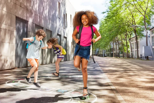 Retrato Niños Saltando Las Plazas Azadón Letras Mirando Cámara Con —  Fotos de Stock