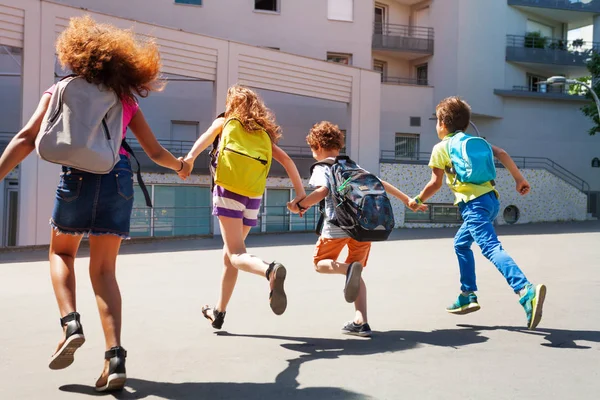 Ομάδα Παιδιών Που Τρέχουν Μαζί Κρατώντας Χέρια Και Φορώντας Σακίδια — Φωτογραφία Αρχείου