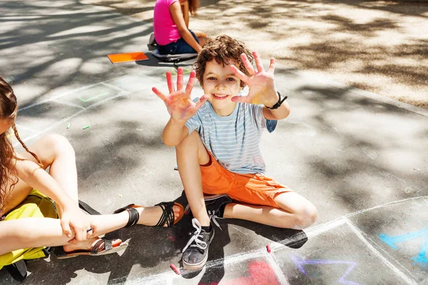 Αγόρι Δείχνει Χέρια Στην Κάμερα Ενώ Παιδιά Ισοπαλία Κιμωλία Στο — Φωτογραφία Αρχείου