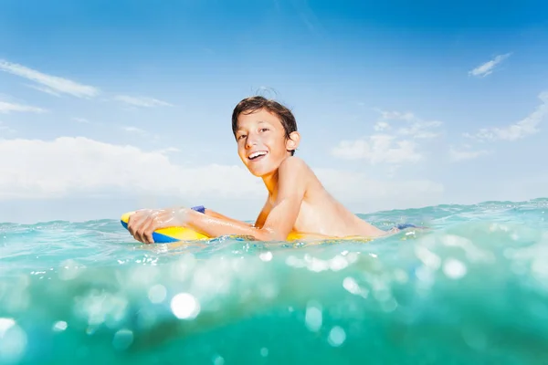 泳ぎに海の波でボディボードの幸せな子供の肖像画 — ストック写真
