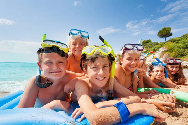 Gran Grupo Niños Yacía Playa Arena Juntos Abrazándose Sonriendo Máscaras — Foto de Stock