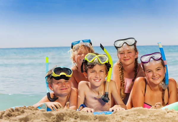 小组男孩和女孩 在海海滩佩带水肺浮潜面具微笑对照相机 — 图库照片