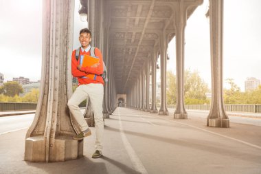 Mutlu genç adamın sırt çantası ve ders kitapları Paris'in merkezine yürüme elinde tam uzunlukta