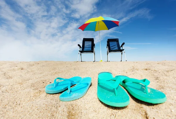 Tropischer Hintergrund Mit Zwei Paar Flip Flops Liegestühlen Und Sonnenschirm — Stockfoto