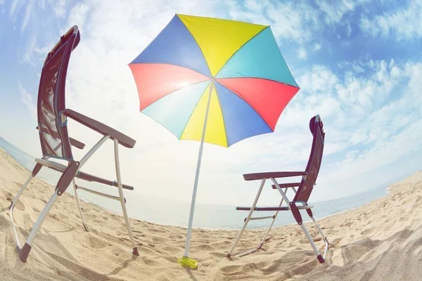 阳光明媚的沙滩上 两张甲板椅站在五彩太阳伞下的鱼眼图片 — 图库照片