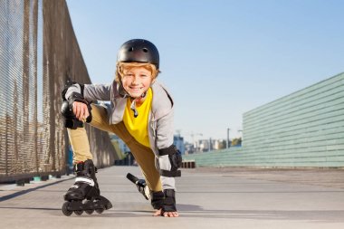 Yakın çekim inline paten ve koruyucu giysiler açık rollerdrom, varoluş sarışın çocuk portresi