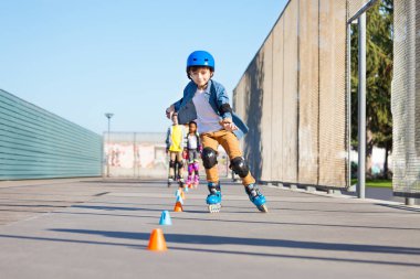 Varoluş çocuk, koruyucu giysiler, mutlu satır içi patenci açık skate park adlı arkadaş grubu slaloming