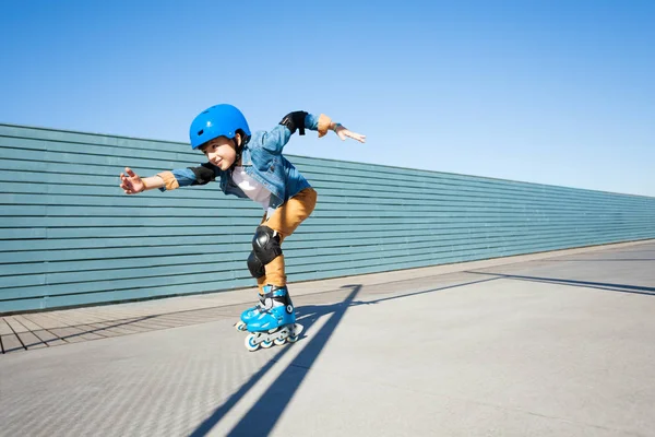 プレティーンの少年 ヘルメットや防護服 屋外の Rollerdrom で高速スケートのローラー スケートの側面図 — ストック写真