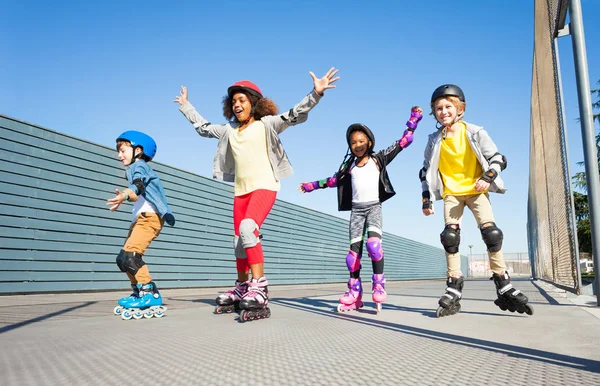 Vier Preteen Kinderen Vreugdevolle Line Schaatsers Helmen Beschermende Kleding Samen — Stockfoto