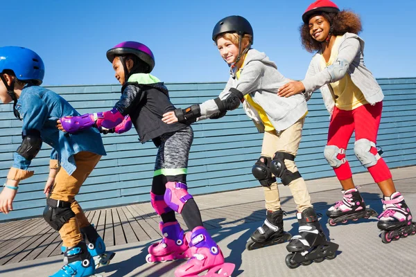 Cuatro Niños Niñas Multiétnicos Felices Divirtiéndose Mientras Patinan Uno Tras —  Fotos de Stock