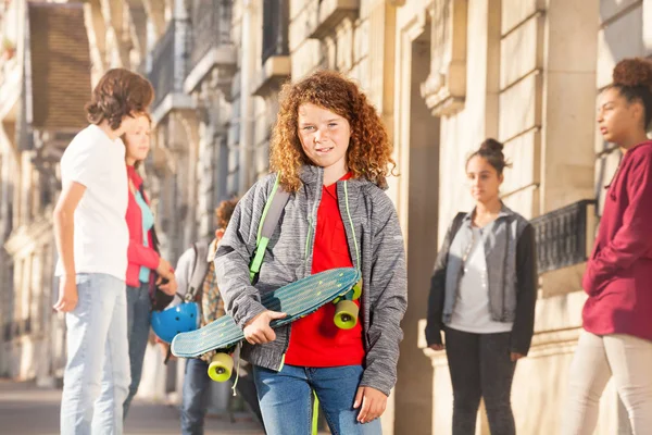 Lindo Adolescente Rizado Con Monopatín Las Calles Urbanas Con Amigos — Foto de Stock