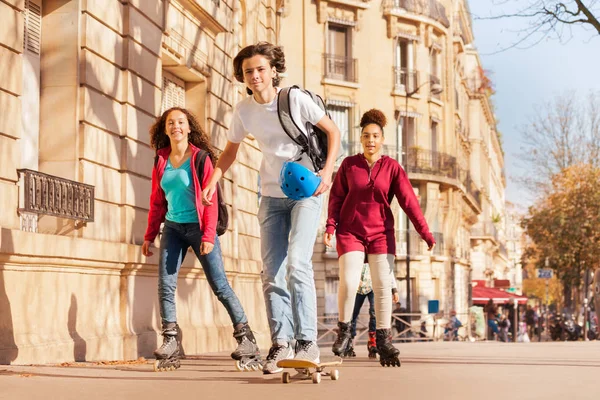 Junge Skateboarden Und Mädchen Inlineskaten Auf Den Straßen Der Stadt — Stockfoto