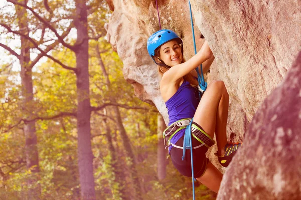 若い女の子がアルピニストの装置を身に着けている山岩の上登って — ストック写真