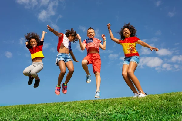 Viele Kinder in verschiedenen Nationalflaggen-Shirts springen — Stockfoto