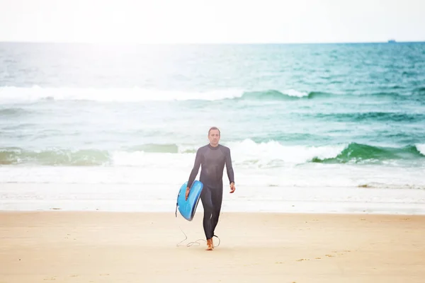 Homme marche avec planche de surf de la mer sur une plage — Photo