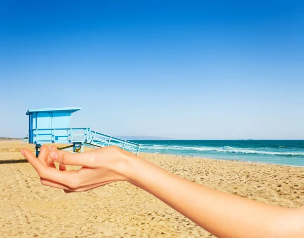 Hand hold between fingers lifeguard tower LA beach — Stock Photo, Image