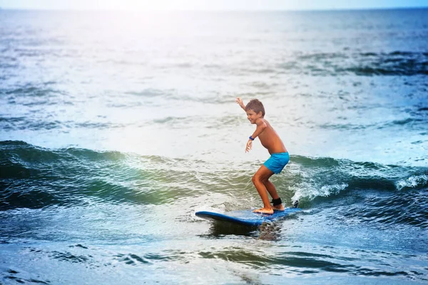 少年は海のサーフボードでバランスをとる — ストック写真