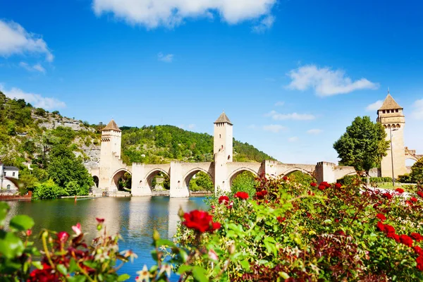 Valentre bridge in Cahor over red flowers, France — Stock Photo, Image