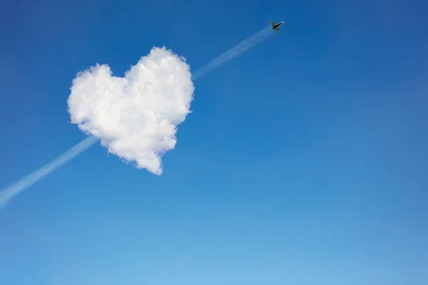 Flugzeug auf dem Weg durch die herzförmige Wolke — Stockfoto