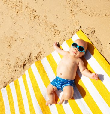 Little toddler baby infant laying on the beach mat