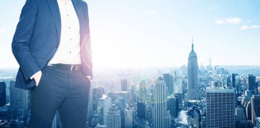 Businessman with suit stand at New York window