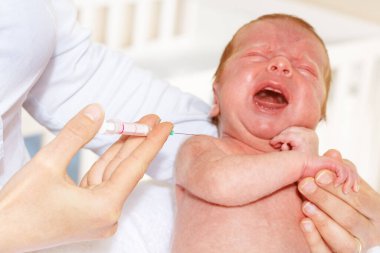 Infant cry at vaccination, syringe on foreground