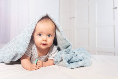 Infant boy crawl out of towel with happy face