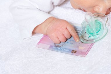 French resident permit in hand of baby, pacifier