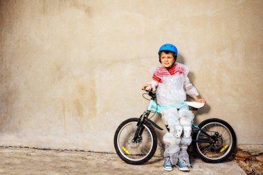 Boy with bicycle in overprotecting bubble wrap