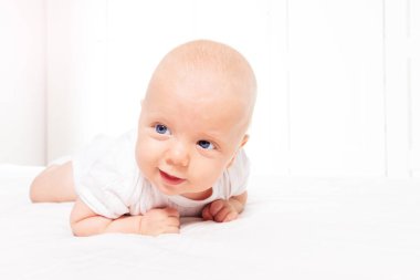 Smiling baby infant boy learn laying on the belly
