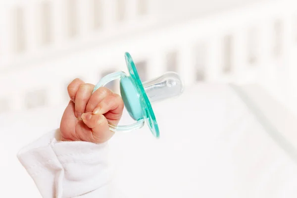 Infant newborn baby hold by hand in air pacifier — Stok fotoğraf