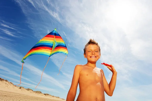 Ragazzino sulla spiaggia con sorriso colorato aquilone — Foto Stock