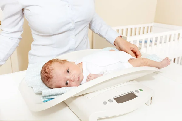 Woman weight cute newborn baby infant boy on scale — Stock Photo, Image