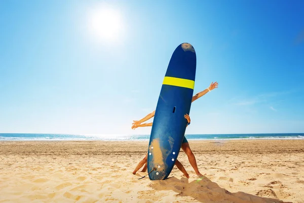 Child and adult behind surf board on a beach pose — 스톡 사진