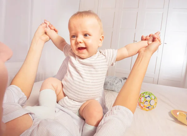 Mère joue avec un petit bébé à genoux — Photo
