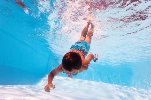 Boy dive in the pool reach bottom with hand — Stock Fotó