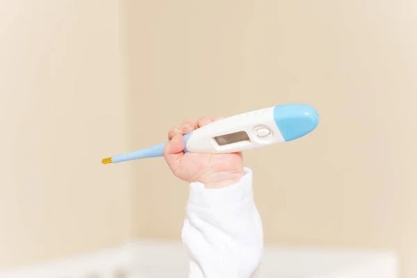 Infant hand hold medical thermometer in the air — Stok fotoğraf