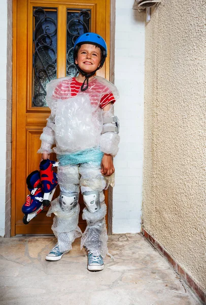 Enfant avec patins près de la porte dans un emballage à bulles — Photo