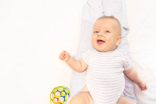 Joyeux petit bébé allongé sur le lit lever les yeux et sourire — Photo