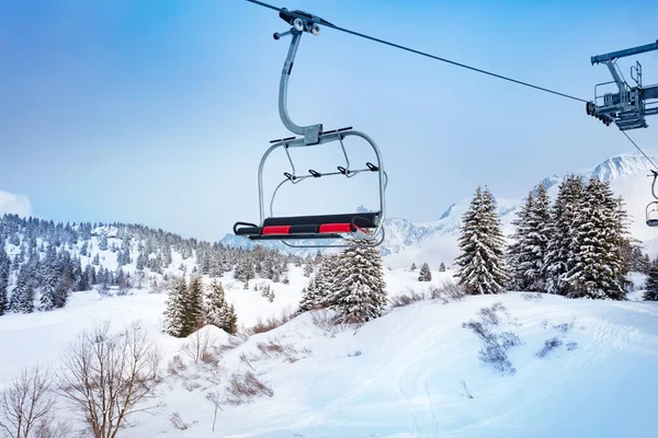 Ski lift chair on Alpine resort over fir forest — Stock Photo, Image