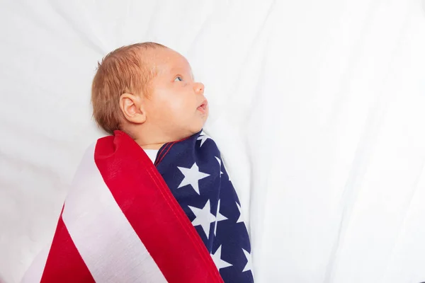 Portrait of calm baby infant wrapped in USA flag — Stockfoto
