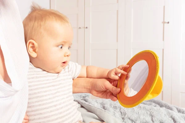 Baby infant look at mirror together with mother — Stockfoto