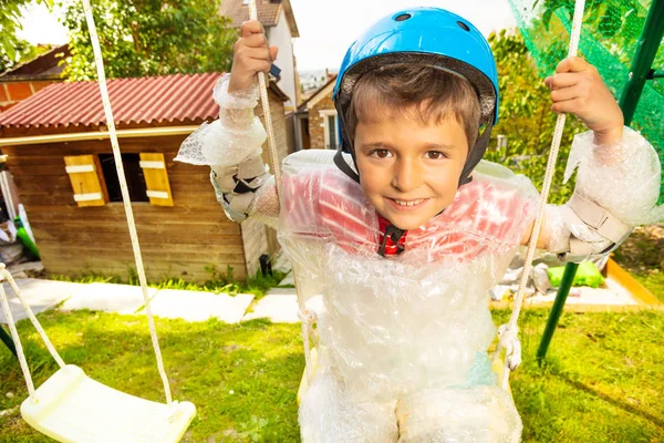 Portrait rapproché d'un enfant dans un emballage à bulles sur balançoire — Photo