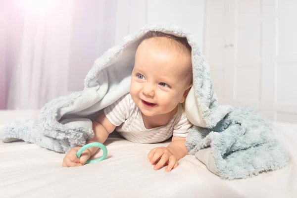 Rapaz bonito rastejar para fora da toalha com rosto sorriso feliz — Fotografia de Stock