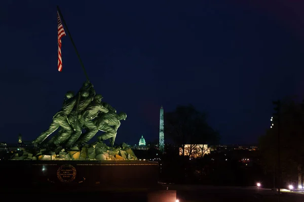 Washington Monument and US Capitol behind Memorial in Washington at night time. The Memorial to honor the Marines who have died defending the US since 1775. — Stock Photo, Image